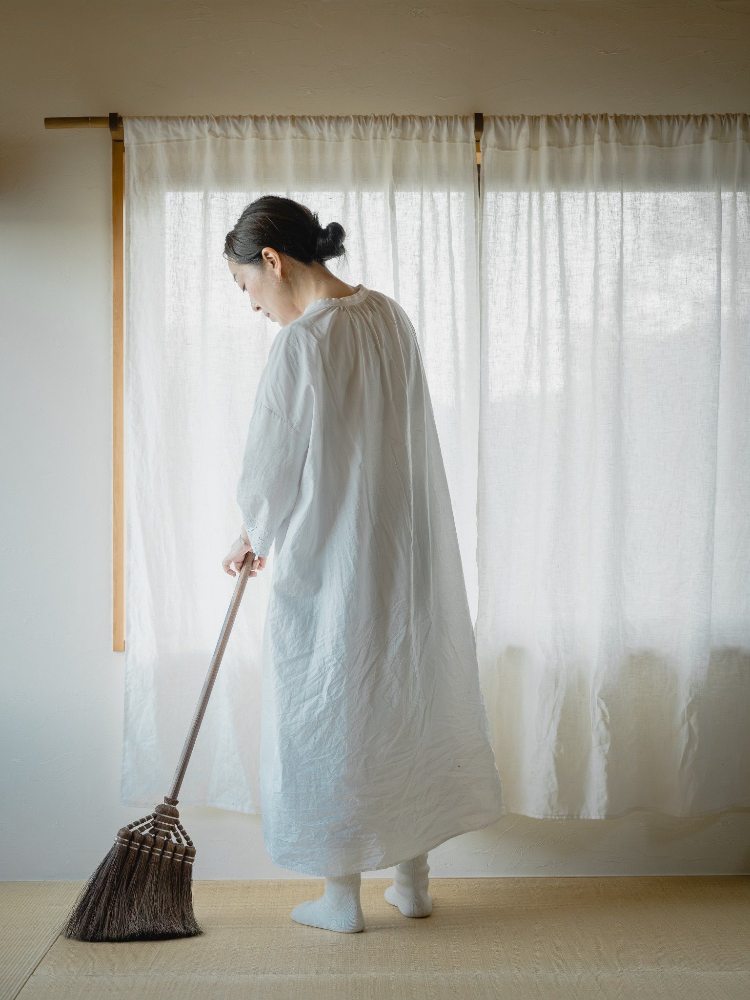 棕櫚ほうきで室内を掃く様子